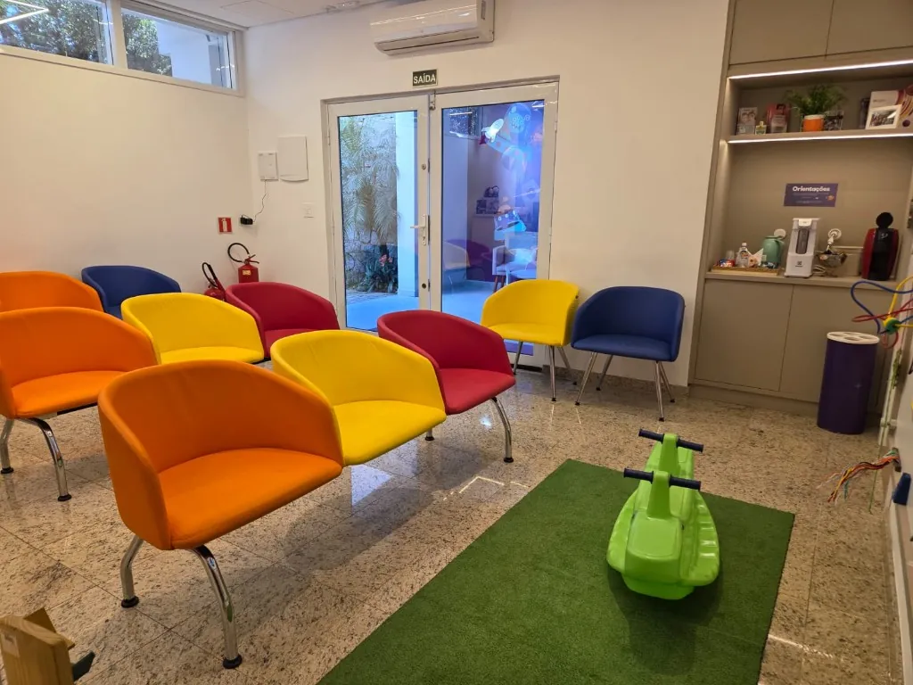 Sala de espera da Oftalmokids com gangorra e cadeiras coloridas
