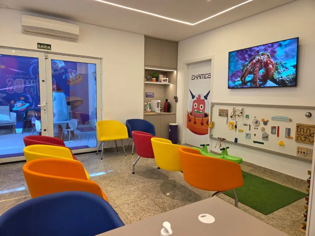 Sala de espera da Oftalmokids com televisão e painel sensorial